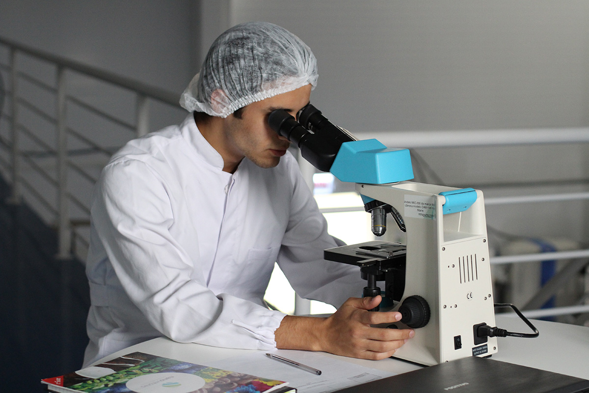 Male scientist looking through a telescope with a hair net on